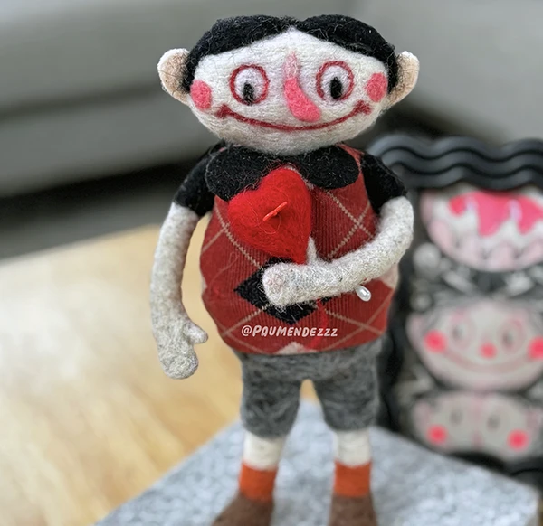 Felt doll holding a red heart