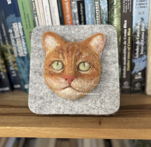 Felt portrait of an orange cat on a grey wool plaque